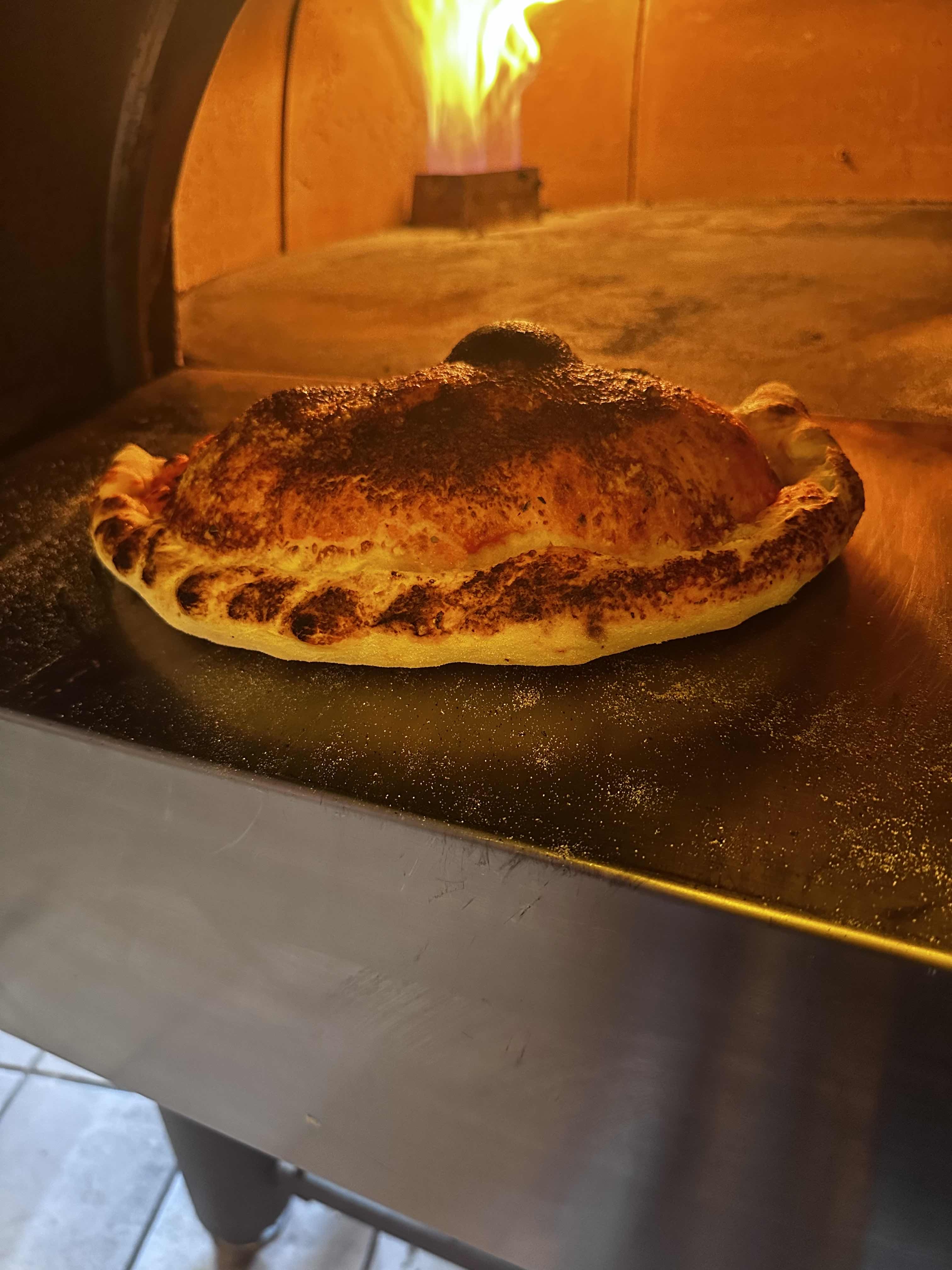 Calzone doré dans le four en flammes